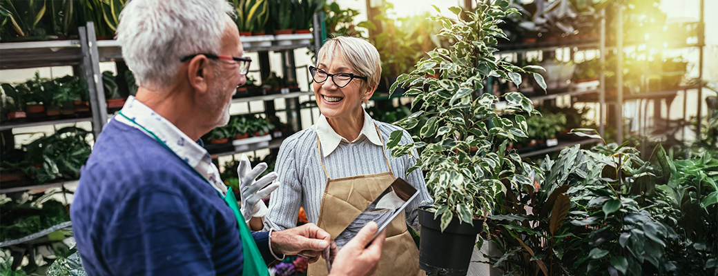 Image of a senior man and woman tending to plants in a greenhouse